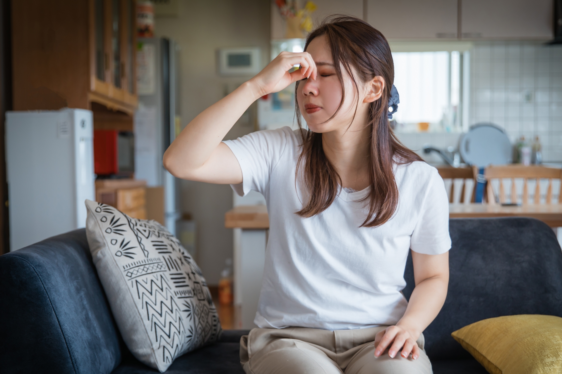 目元を抑えて辛そうな女性（参考イメージ）