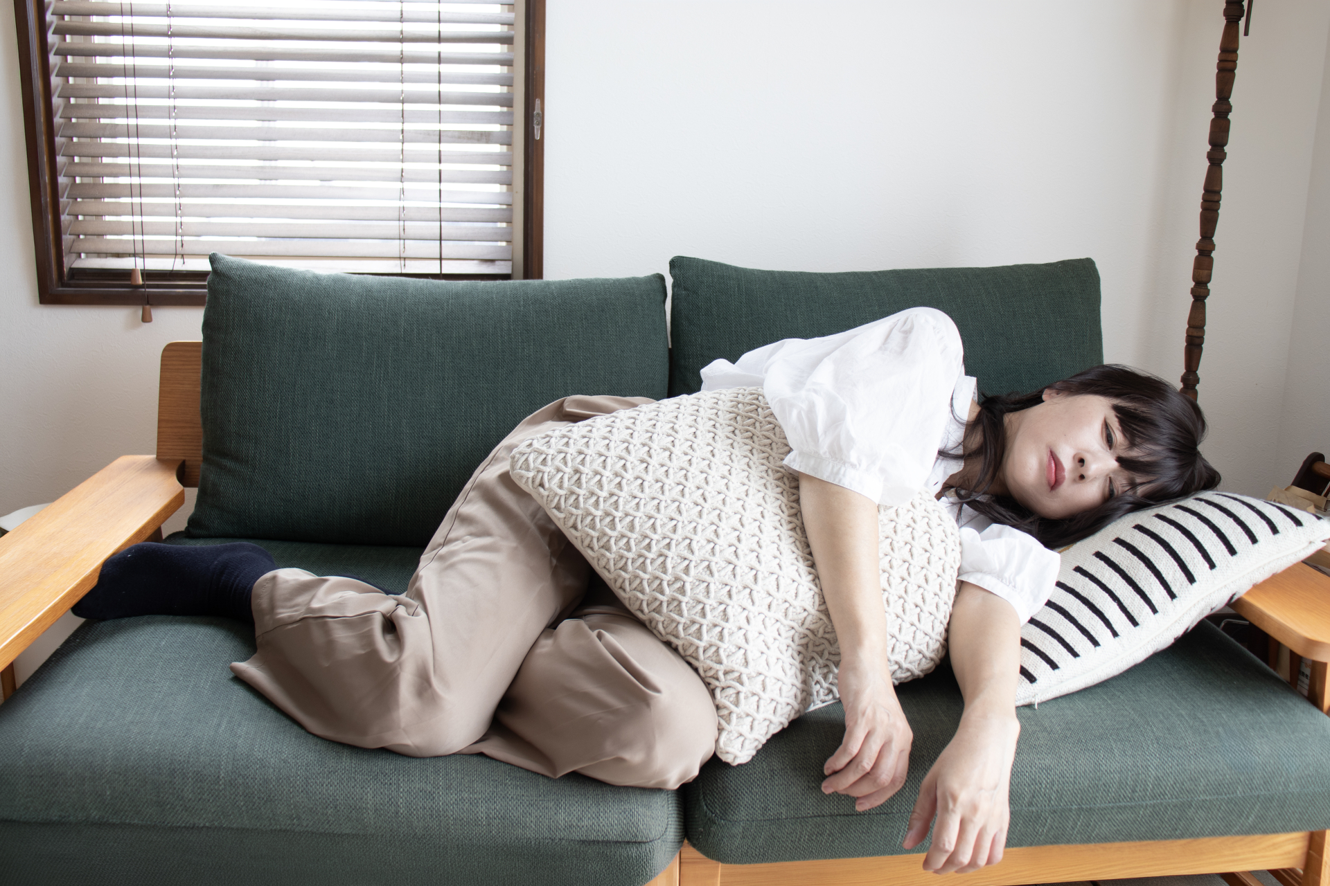 「ソファでぐったりする疲れた女性」（参考イメージ）