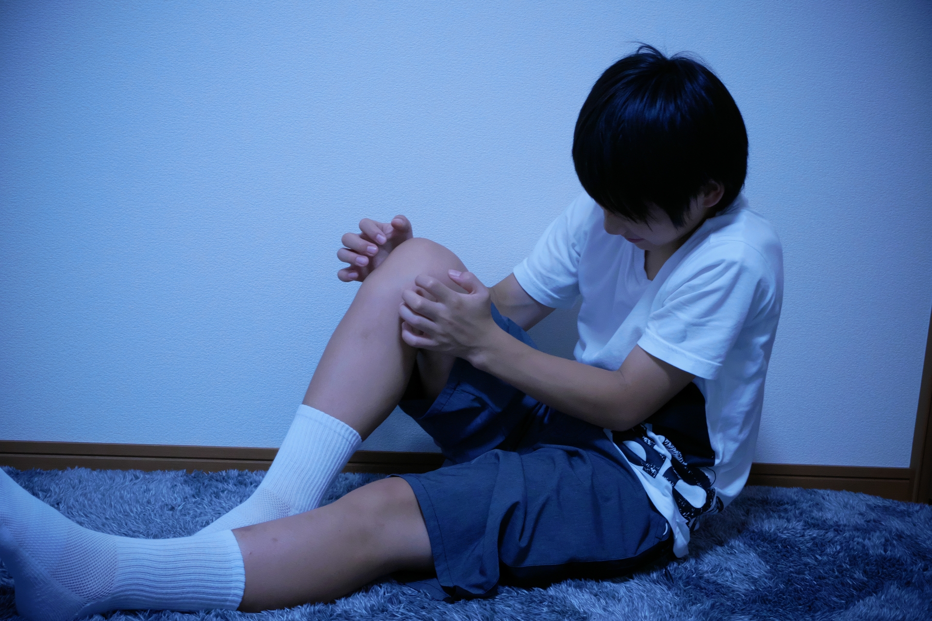 膝の痛みを訴える男の子。（参考イメージ）
