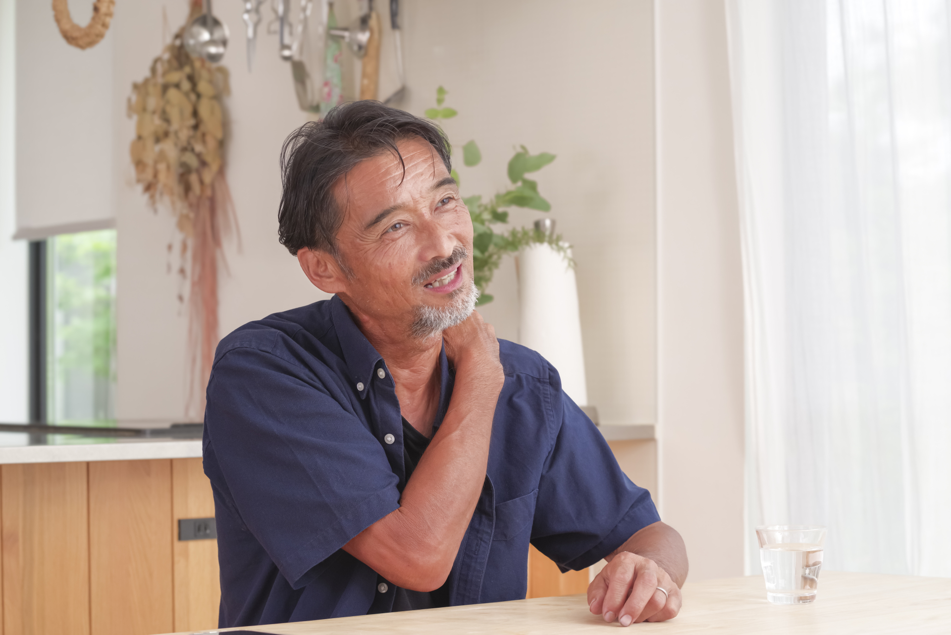 首から肩にかけて痛みを感じる男性（参考イメージ）